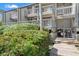 Condo exterior featuring stacked private balconies, lush greenery, and wooden stairway at 1619 Live Oak Park, Johns Island, SC 29455