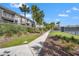 Exterior view of well-maintained condo buildings, lush landscaping, and path leading to community tennis courts at 1619 Live Oak Park, Johns Island, SC 29455