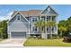 Charming two-story home with a garage, palm trees, a yellow front door, and a cozy bench in the front yard at 1644 Fort Palmetto Cir, Mount Pleasant, SC 29466