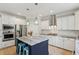 Modern kitchen showcasing white cabinets, stainless steel appliances, a stylish island with seating, and a custom range hood at 1644 Fort Palmetto Cir, Mount Pleasant, SC 29466