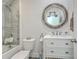 Elegant bathroom featuring a marble top vanity with a unique round mirror, toilet, and walk-in shower at 169 Jackson St, Charleston, SC 29403