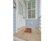 Close-up of front door area with welcome mat on cozy wooden porch at 169 Jackson St, Charleston, SC 29403