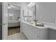 A well-lit bathroom transitions from a bedroom, boasting a vanity, a mirror, and a view of the bedroom at 1735 Telfair Way, Charleston, SC 29412