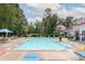Community swimming pool with lounge chairs and umbrellas surrounded by mature trees on a bright day at 1735 Telfair Way, Charleston, SC 29412