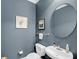 Stylish powder room features blue walls, round mirror, modern fixtures, and elegant decor at 200 River Landing Dr # D310, Charleston, SC 29492