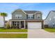 Inviting two-story home with a landscaped front yard, charming brick accents, and an attached two-car garage at 205 Honey Horn Dr, Summerville, SC 29486