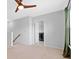 Upstairs landing area featuring carpeted floors, a ceiling fan, and a laundry area behind a white door at 205 Honey Horn Dr, Summerville, SC 29486