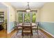 A charming dining room features a round table set under a decorative light fixture and a large bay window at 2144 Pinopolis Rd, Pinopolis, SC 29469