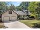 Exterior of a charming home featuring a two-car garage, ample parking space, and attractive landscaping at 2144 Pinopolis Rd, Pinopolis, SC 29469