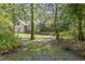 Exterior view through trees revealing a charming home and screened porch with inviting curb appeal at 2144 Pinopolis Rd, Pinopolis, SC 29469
