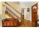 Foyer with hardwood floors, staircase, and a wooden storage bench, creating a welcoming entrance at 2144 Pinopolis Rd, Pinopolis, SC 29469
