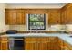A kitchen view showcasing wood cabinets, neutral countertops, and a stainless steel dishwasher at 2144 Pinopolis Rd, Pinopolis, SC 29469