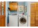 Functional laundry room with washer, dryer, wooden cabinets, and a window at 2144 Pinopolis Rd, Pinopolis, SC 29469