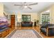 A cozy living room featuring a black leather sofa, a ceiling fan, and wood floors with an area rug at 2144 Pinopolis Rd, Pinopolis, SC 29469
