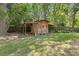 A charming wooden shed with a covered area for storage in a spacious yard at 2144 Pinopolis Rd, Pinopolis, SC 29469