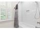 Close-up of a white subway tiled shower over tub with white shutters at 2159 Parkway Dr, Charleston, SC 29412