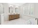 Bright bathroom boasts a wooden double vanity, marble countertop, and a large window with plantation shutters at 2159 Parkway Dr, Charleston, SC 29412