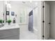 Bright bathroom with double vanity, subway tiled shower/tub with blue accents, and plantation shutters at 2159 Parkway Dr, Charleston, SC 29412