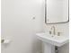 Elegant powder room with white pedestal sink, gold hardware, and a sleek rectangular mirror at 2159 Parkway Dr, Charleston, SC 29412