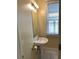 This half bath features a pedestal sink, a rectangular mirror, and a window with white blinds, making it a cozy space at 22A Corinne St # 31, Charleston, SC 29403
