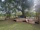 Picturesque backyard with a large wooden deck and a charming blue cottage-style playhouse at 228 Dogwood Trl, Harleyville, SC 29448