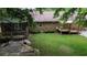 Sprawling backyard featuring a deck, lush lawn, and a charming brick house exterior at 228 Dogwood Trl, Harleyville, SC 29448