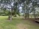 Expansive backyard with mature trees, a storage shed, and tasteful landscaping with well-manicured lawn at 228 Dogwood Trl, Harleyville, SC 29448