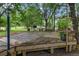 Spacious wooden deck featuring planters, lighting, and views of the surrounding greenery, ideal for relaxation and outdoor activities at 228 Dogwood Trl, Harleyville, SC 29448