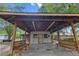 Exterior of a gray building featuring an attached drive-through canopy and wooden bench seats at 228 Dogwood Trl, Harleyville, SC 29448