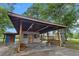 Exterior of a gray building featuring an attached drive-through canopy and wooden bench seats at 228 Dogwood Trl, Harleyville, SC 29448