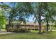 Charming brick home with a welcoming front porch and lush landscaping, shaded by mature trees on a well-manicured lawn at 228 Dogwood Trl, Harleyville, SC 29448