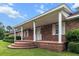 Inviting brick front porch with elegant white columns and a stepped entrance at 228 Dogwood Trl, Harleyville, SC 29448