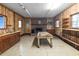 Rustic interior with wood-paneled walls, featuring a brick fireplace, wooden table, and functional sink, offering a versatile space at 228 Dogwood Trl, Harleyville, SC 29448