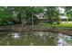 This backyard features a tranquil pond with a wooden fence, enhancing the property's charm at 228 Dogwood Trl, Harleyville, SC 29448