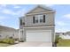 Two-story home boasts grey siding, black shutters, a two-car garage, and a well-maintained lawn at 244 Wild Strawberry Ln, Moncks Corner, SC 29461