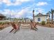 A cozy brick fire pit surrounded by Adirondack chairs next to the pool for community gatherings at 244 Wild Strawberry Ln, Moncks Corner, SC 29461