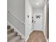 Bright hallway with wood floors features a carpeted staircase and a view of the front door at 244 Wild Strawberry Ln, Moncks Corner, SC 29461