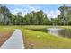 Picturesque view of a pond with a fountain along a curving walking path surrounded by nature at 244 Wild Strawberry Ln, Moncks Corner, SC 29461