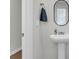Powder room with pedestal sink, oval mirror, towel ring, and a door ajar at 244 Wild Strawberry Ln, Moncks Corner, SC 29461