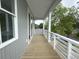 Covered outdoor balcony featuring wooden floors and a white railing, perfect for enjoying the view at 2508 Corona St, North Charleston, SC 29405