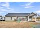 Rear exterior of the home features a delightful back porch with hot tub, grill, and yard at 255 S Railroad Ave, Ridgeville, SC 29472
