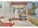 Cozy back porch with a grill, comfortable seating, and privacy curtains provides a tranquil outdoor space at 255 S Railroad Ave, Ridgeville, SC 29472