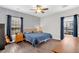 Bedroom with wood floors, accent wall, curtains, ceiling fan, and a large window at 255 S Railroad Ave, Ridgeville, SC 29472
