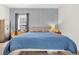 Serene bedroom with a blue quilt, decorative wallpaper, and ample natural light from the window at 255 S Railroad Ave, Ridgeville, SC 29472