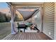 Back porch with a grill, seating, shade, and hot tub for an awesome entertaining and relaxing space at 255 S Railroad Ave, Ridgeville, SC 29472