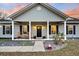 Attractive home exterior featuring a covered front porch with rocking chairs and a neatly landscaped yard with charming details at 255 S Railroad Ave, Ridgeville, SC 29472