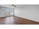 A well-lit bedroom featuring dark wood floors, a ceiling fan, and a bright window providing outside views and natural light at 259 E Bay St # 7C, Charleston, SC 29401