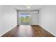 A spacious bedroom featuring dark wood floors and a sliding glass door with a balcony, allowing for natural light at 259 E Bay St # 7C, Charleston, SC 29401