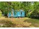 Backyard shows a blue home surrounded by abundant greenery and foliage at 2654 Harvey Ave, North Charleston, SC 29405