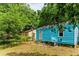 Backyard with a blue home exterior, surrounded by trees and greenery at 2654 Harvey Ave, North Charleston, SC 29405